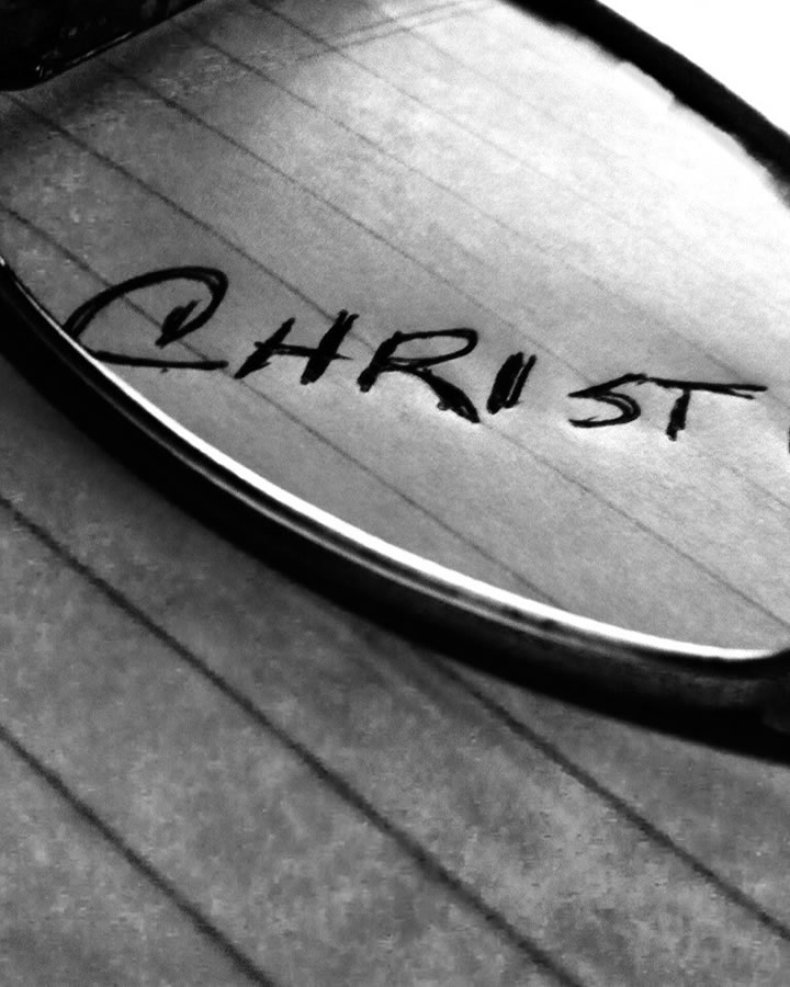 "Christ" written on ruled paper graphic.